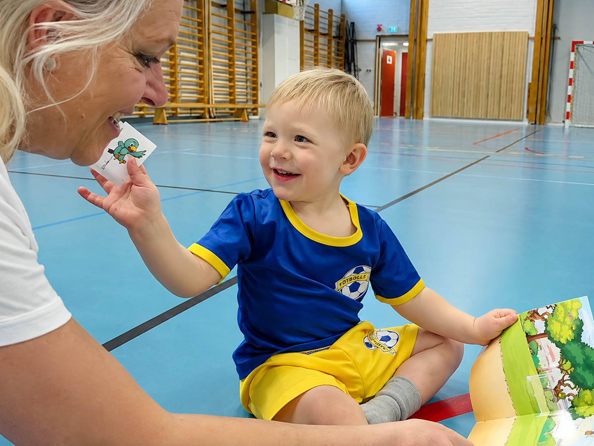 Barn i fotbollsdräkt tittar på klistermärke
