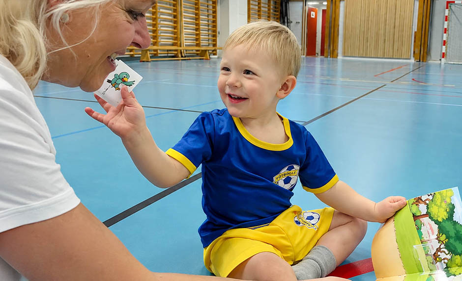 Barn i fotbollsdräkt tittar på klistermärke